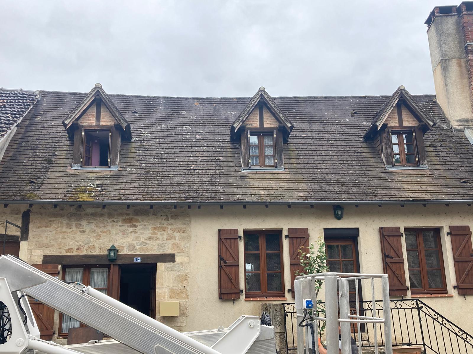 Toiture ancienne d'une maison en pierre encrassée avant nettoyage